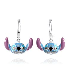 pair of blue and purple cartoon character earrings with swarong eyes on white background