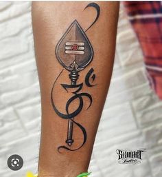 a tattoo on the leg of a person with a key in it and an arrow