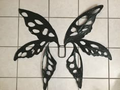 two metal butterflies sitting on top of a tiled floor