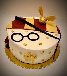 a harry potter themed birthday cake with gold stars and glasses on it's side