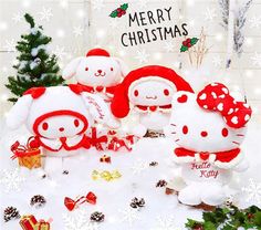 three hello kitty stuffed animals are sitting in the snow with christmas decorations and presents around them