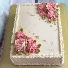 a cake with white frosting and pink flowers on it