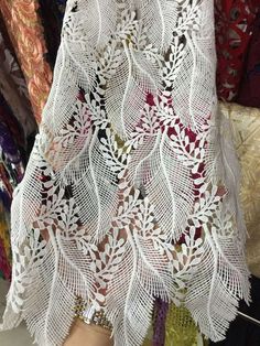 white crocheted lace is being displayed in a store