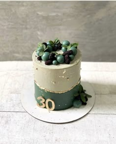 a three tiered cake with berries and leaves on top