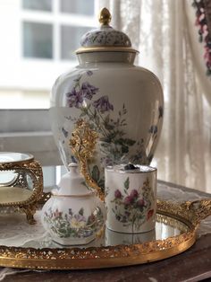 an ornately decorated tea set sits on a tray