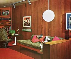 a living room filled with lots of furniture and bookshelves next to a wooden wall