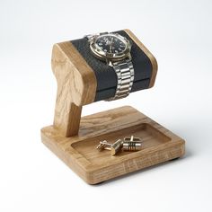 a watch and cufflinks on a wooden stand