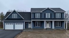 a blue house with two garages and three windows