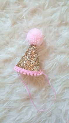 "READY TO SHIP as shown Non shedding glitter Mini Party Hat Pale gold hat Baby pink trim and pom Shown as is without a number If you would like a number please message for a custom order Mini party hat measures 3\" tall x 2.5\" in diameter" Pink Cake Smash, Mini Party Hats, First Birthday Hats, 1st Birthday Photoshoot, Gold Hats, Beautiful Nursery, Cake Smash Photos, Mini Party, Gold And Pink