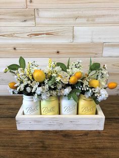 three mason jars filled with lemons and white flowers