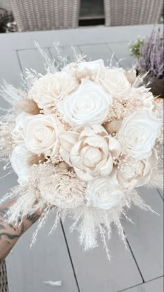 a bridal bouquet with white roses and feathers