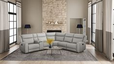 a living room with a large sectional couch and two lamps on the side of the wall