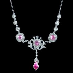 A fabulous antique Edwardian lavaliere necklace from the early 20th Century decorated with glistening white pastes and three larger pink pastes along the bottom of the gallery.  It's fashioned entirely in silver and has a wonderful geometric design with flowing, foliate motifs. It's in excellent condition and would be perfect for a wedding or glamorous occasion. Weighs: 12.4 grams Measures: 18.5 inches in length - Dropper 7mm across x 13mm down Age: Edwardian. (Circa 1901 - 1915) Condition: exce Victorian Silver Necklace With Diamond Accents, Antique Pink Jewelry With Rose Cut Diamonds, Antique Pink Rose Cut Diamond Jewelry, Victorian Pink Rose Cut Diamond Jewelry, Vintage Pink Gemstone Necklace, Antique Pink Necklaces For Wedding, Victorian Pink Diamond Jewelry, Vintage Pink Necklace With 17 Jewels, Vintage Pink Sterling Silver Necklace