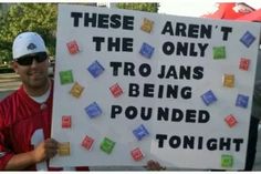 a man holding a sign that says, these aren't the only tro jans being rounded tonight