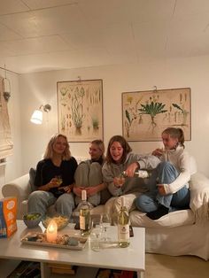 a group of people sitting on top of a white couch