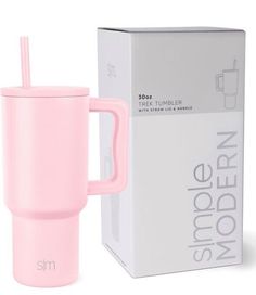 a pink cup with a straw in it next to a box