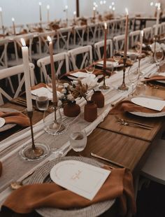 a long table set with place settings and candles