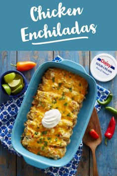 chicken enchiladas in a blue casserole dish with sour cream on top