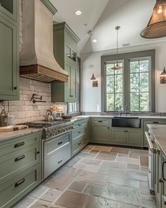 a large kitchen with green cabinets and marble counter tops