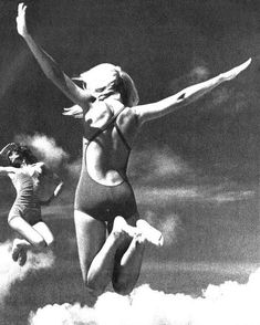 two women in swimsuits jumping into the air