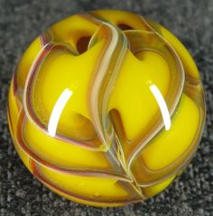 a yellow glass ball sitting on top of a carpet