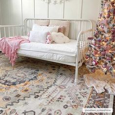 a white day bed sitting next to a christmas tree