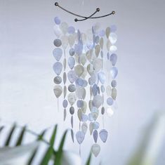 a wind chime hanging from a ceiling next to a plant