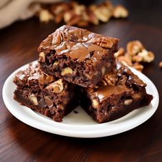 some brownies are stacked on top of each other with walnuts in the background