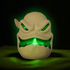 a white mask with glowing green eyes