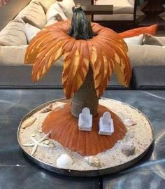 a fake pumpkin sitting on top of a table next to a number plate with an orange flower