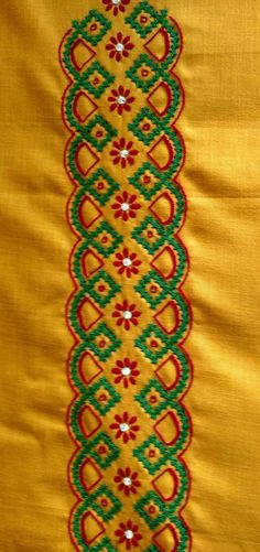 an embroidered yellow cloth with green and red designs