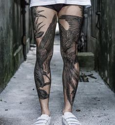 a person with tattoos on their legs and leggings