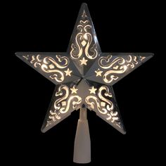 a lighted christmas star with swirls and stars on the side, against a black background