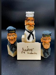 three figurines in the shape of sailors are posed next to a sign that says anken's woodworking