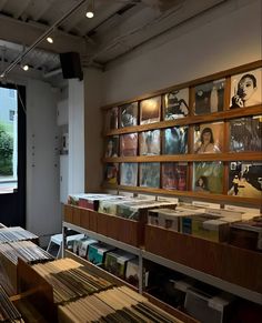 a room filled with lots of records on the wall and wooden tables in front of it