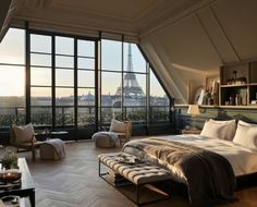 a bedroom with a view of the eiffel tower from it's windows