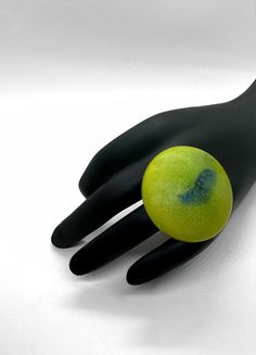 a black hand with a green ball on it