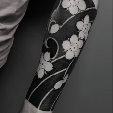 a man with a black and white flower tattoo on his arm