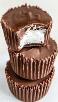 three chocolate cups stacked on top of each other with white frosting in the middle