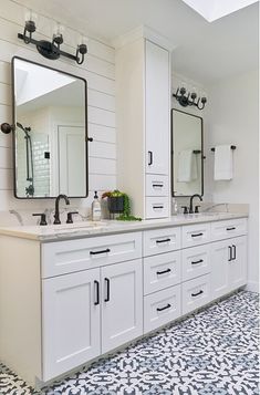 a bathroom with two sinks, mirrors and tiled flooring in black and white colors