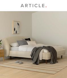 a white bed sitting on top of a wooden floor