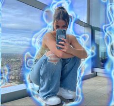 a woman sitting on top of a window sill holding a cell phone in her hand