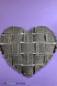 a heart made out of woven material on a purple background