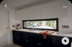 a kitchen with black cabinets and white countertops has a red ribbon tied around the sink