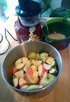 apples are in a bowl next to a blender