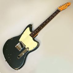 a black and yellow electric guitar sitting on top of a white table next to a wall