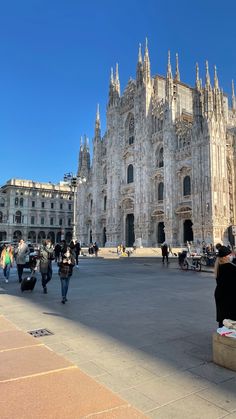 people are walking around in front of the cathedral