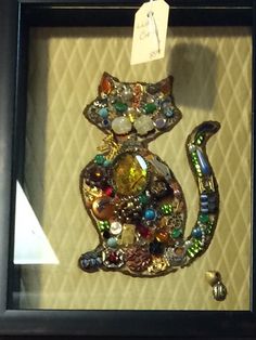 a cat made out of buttons in a shadow box with a price tag on it