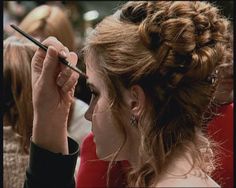 a woman is getting her make up done by another person in a crowd at an event