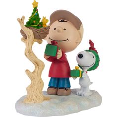 a charlie brown christmas ornament with a dog and tree on it's side